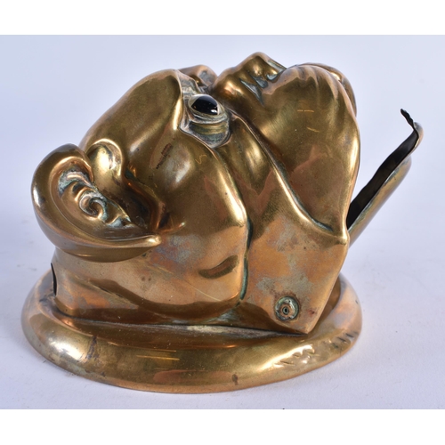 397 - AN ANTIQUE ARTICULATED BRASS GLASS EYED BULLDOG WALL MOUNT possibly formerly a bell. 12 cm wide.