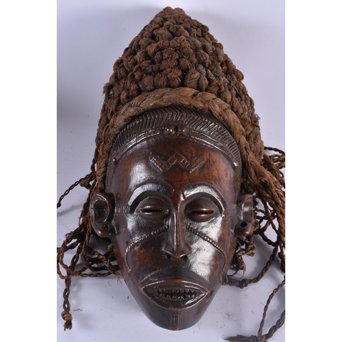 400 - TWO EARLY 20TH CENTURY AFRICAN LWENA TRIBAL WOOD MASKS together with a Chokwe mask. Largest 38 cm x ... 