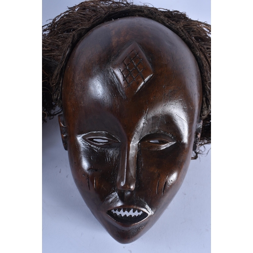 400 - TWO EARLY 20TH CENTURY AFRICAN LWENA TRIBAL WOOD MASKS together with a Chokwe mask. Largest 38 cm x ... 