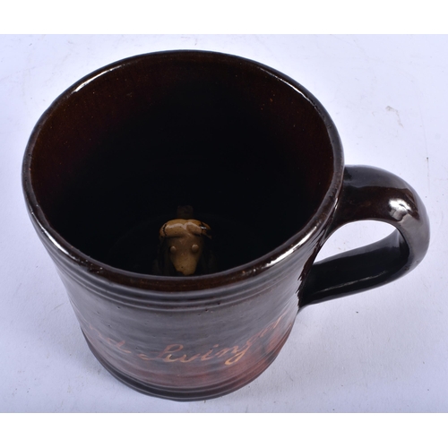 482 - A VERY UNUSUAL 19TH CENTURY ENGLISH TREACLE GLAZED SURPRISE MUG unusually formed with a recumbent do... 