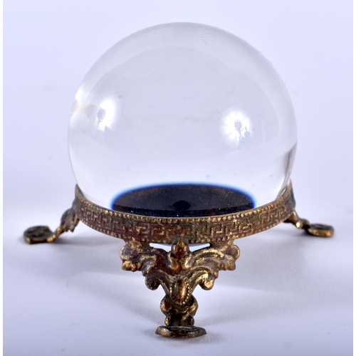 584 - AN ANTIQUE CRYSTAL BALL upon a gilt metal base. 5.25cm wide.