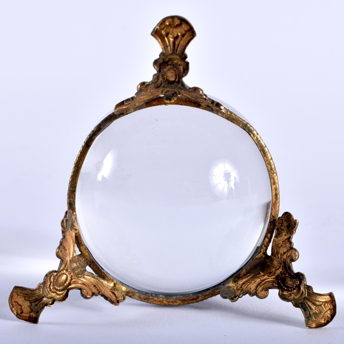 584 - AN ANTIQUE CRYSTAL BALL upon a gilt metal base. 5.25cm wide.