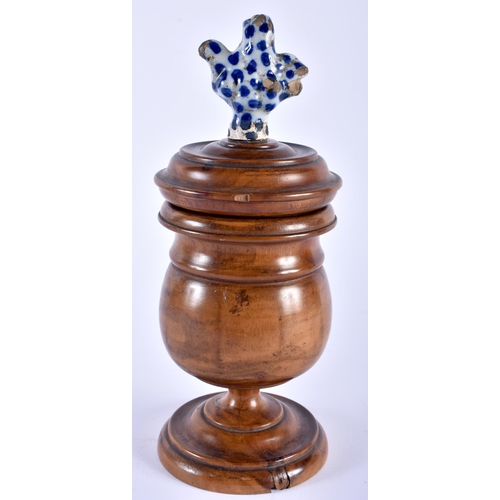 585 - AN 18TH/19TH CENTURY CARVED TREEN VASE AND COVER with 18th century Delft pottery finial. 24 cm high.