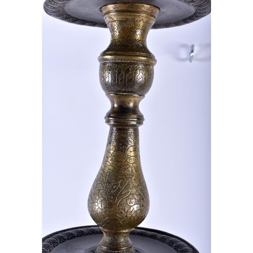 607 - A LARGE 18TH CENTURY ISLAMIC PERSIAN MIDDLE EASTERN BRONZE CANDLESTICK engraved all over with foliag... 