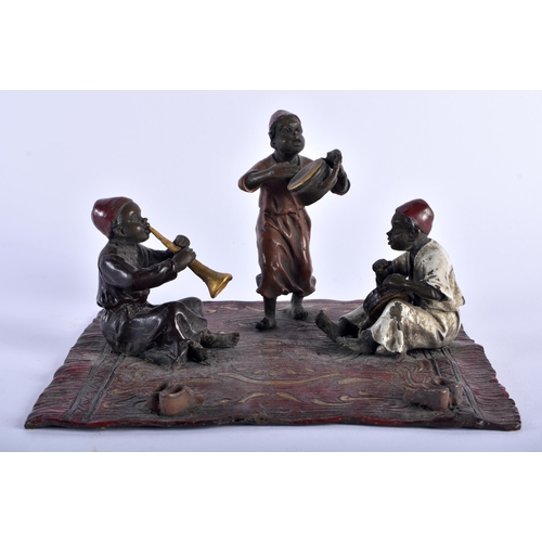 621 - A CONTINENTAL COLD PAINTED BRONZE FIGURAL GROUP modelled as three figures upon a rug. 15 cm square.