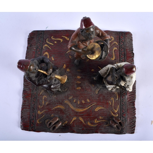 621 - A CONTINENTAL COLD PAINTED BRONZE FIGURAL GROUP modelled as three figures upon a rug. 15 cm square.