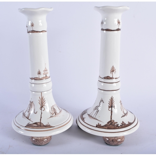 745 - A PAIR OF OXFORD IRIS POTTERY DELFT STYLE CANDLESTICKS. 21.5 cm high.