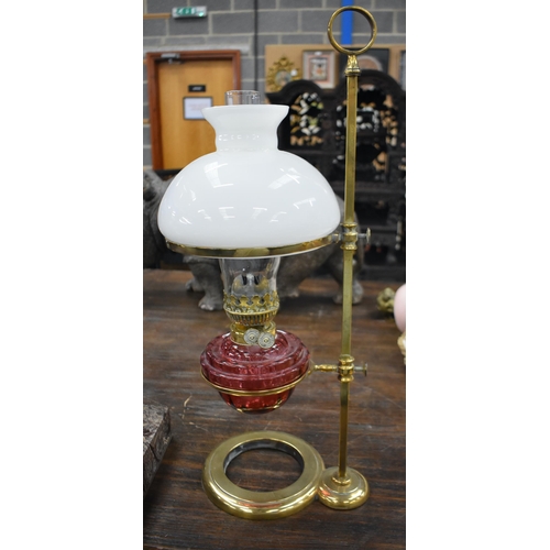 750 - A LARGE BRASS AND CRANBERRY GLASS ADJUSTABLE OIL LAMP. 62 cm high.