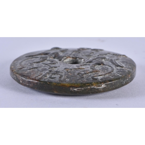 1001 - A RARE CHINESE QING DYNASTY CARVED JADE ROUNDEL decorated with figures and archaic motifs. 83.4 gram... 