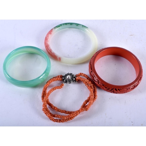 1418 - Two Jade Bangles, an Oriental Carved Dragon Bangle and a Coral Bracelet. Internal diameter 7cm (4)