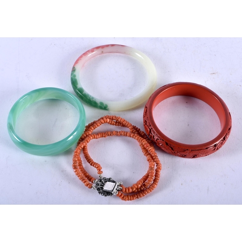 1418 - Two Jade Bangles, an Oriental Carved Dragon Bangle and a Coral Bracelet. Internal diameter 7cm (4)