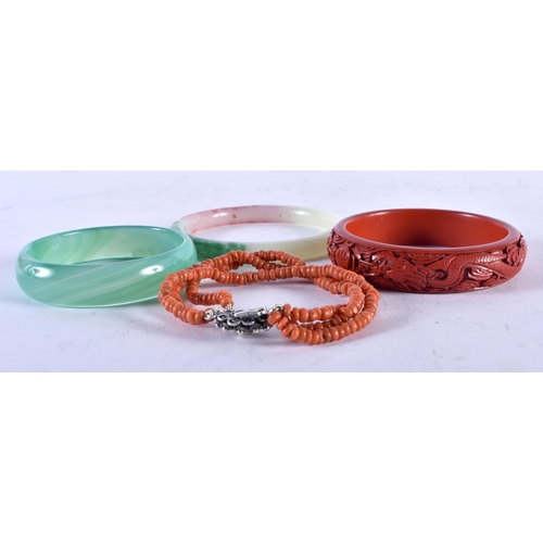 1418 - Two Jade Bangles, an Oriental Carved Dragon Bangle and a Coral Bracelet. Internal diameter 7cm (4)