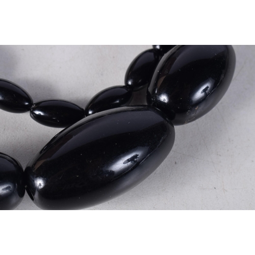 1608 - A LARGE DARK CHERRY AMBER NECKLACE. 93 grams. 68 cm long, largest bead 3.75 cm x 2 cm.