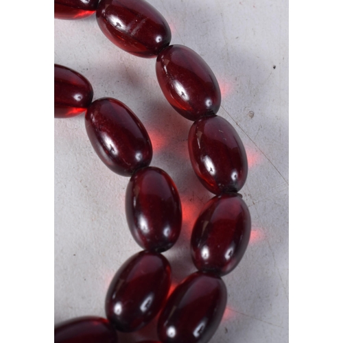 1610 - A CHERRY AMBER TYPE NECKLACE. 23 grams. 55 cm long, each bead 1 cm x 0.5 cm.