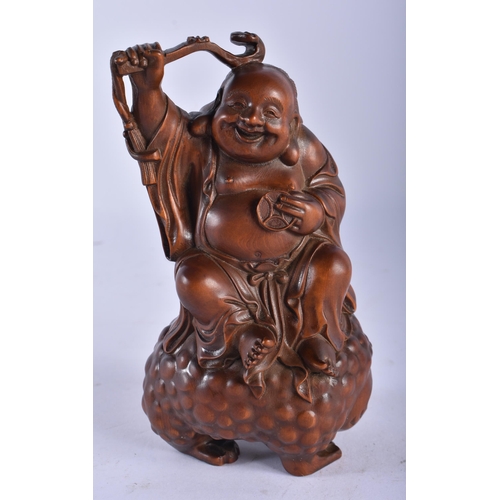 2230 - A 19TH CENTURY JAPANESE MEIJI PERIOD CARVED WOOD OKIMONO modelled as a male seated upon a spotted to... 