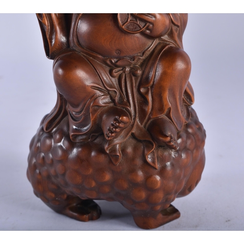 2230 - A 19TH CENTURY JAPANESE MEIJI PERIOD CARVED WOOD OKIMONO modelled as a male seated upon a spotted to... 