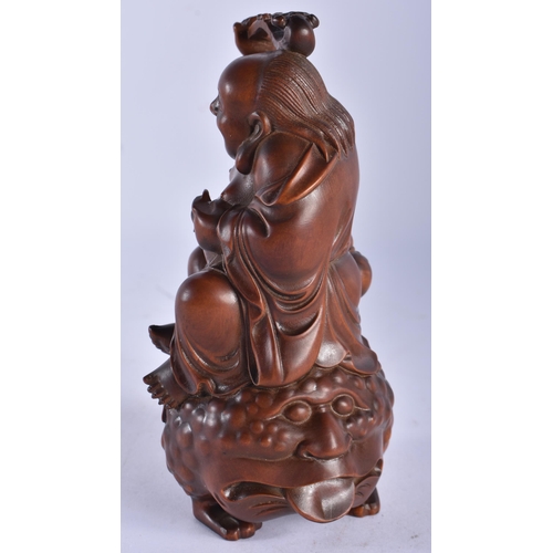 2230 - A 19TH CENTURY JAPANESE MEIJI PERIOD CARVED WOOD OKIMONO modelled as a male seated upon a spotted to... 