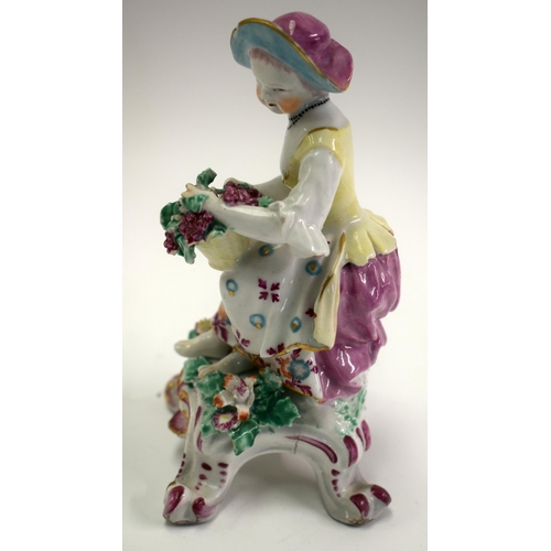 176 - 18th century Bow male figure of autumn, holding a basket of grapes, seated on a rococo base. 16cm hi... 