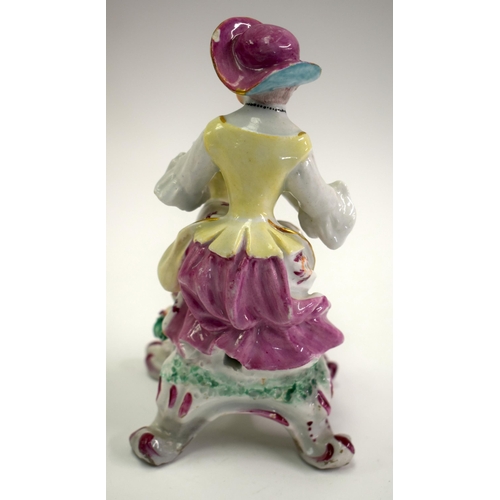 176 - 18th century Bow male figure of autumn, holding a basket of grapes, seated on a rococo base. 16cm hi... 