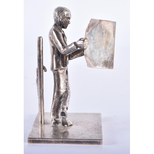 107 - AN ENGLISH SILVER FIGURE OF A MALE modelled reading a newspaper. 80 grams. 8 cm high.