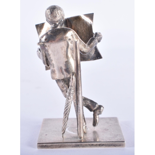 107 - AN ENGLISH SILVER FIGURE OF A MALE modelled reading a newspaper. 80 grams. 8 cm high.