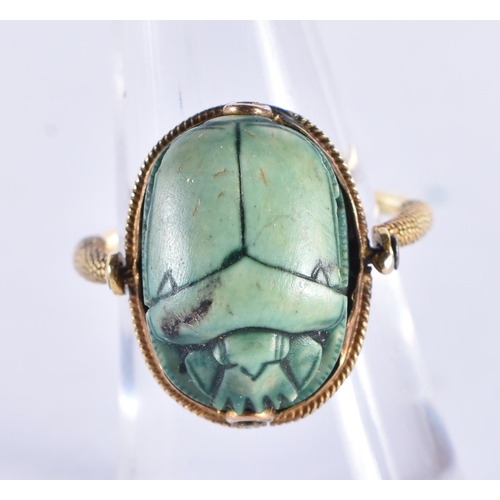 296 - AN EARLY EGYPTIAN FAIENCE SCARAB BEETLE RING the reverse carved with figures and a boat. Beetle 1.75... 