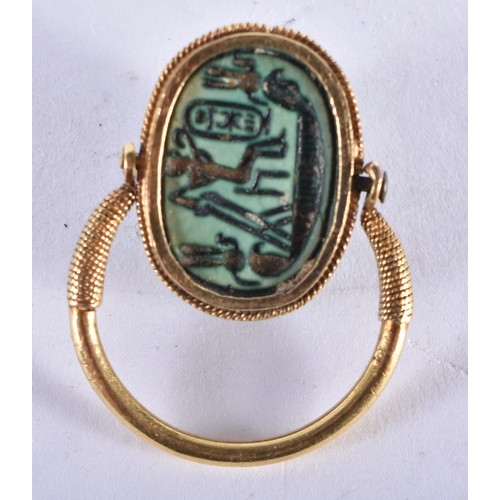 296 - AN EARLY EGYPTIAN FAIENCE SCARAB BEETLE RING the reverse carved with figures and a boat. Beetle 1.75... 