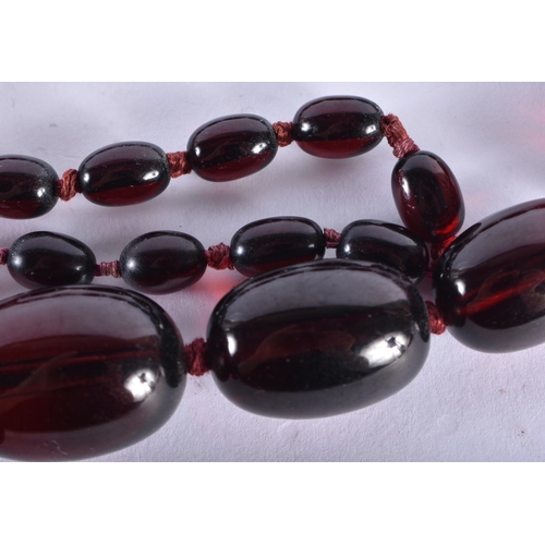 298 - A CHERRY AMBER TYPE NECKLACE. 96 cm long, largest bead 3 cm x 2.25 cm. 104 grams.