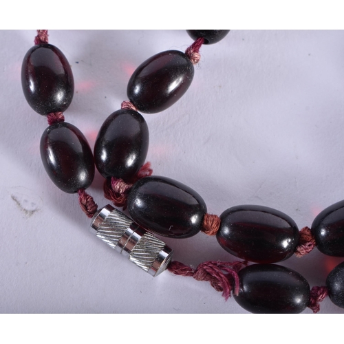 298 - A CHERRY AMBER TYPE NECKLACE. 96 cm long, largest bead 3 cm x 2.25 cm. 104 grams.