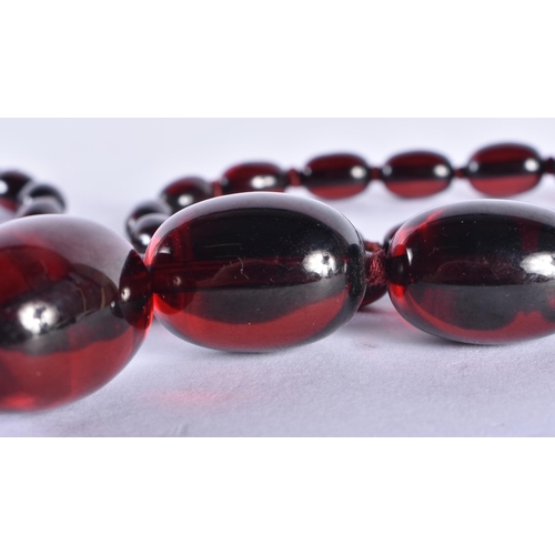 298 - A CHERRY AMBER TYPE NECKLACE. 96 cm long, largest bead 3 cm x 2.25 cm. 104 grams.