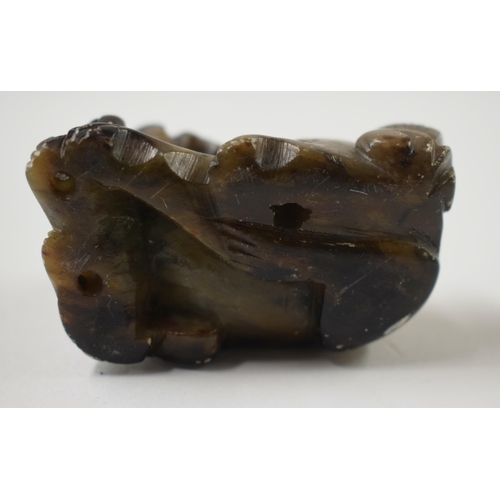 487 - A 19TH CENTURY CHINESE CARVED GREENISH JADE BELT HOOK together with a stone beast. Largest 11cm wide... 