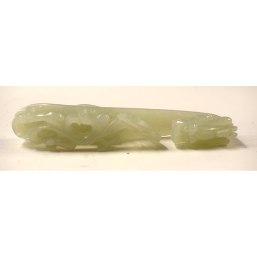 487 - A 19TH CENTURY CHINESE CARVED GREENISH JADE BELT HOOK together with a stone beast. Largest 11cm wide... 