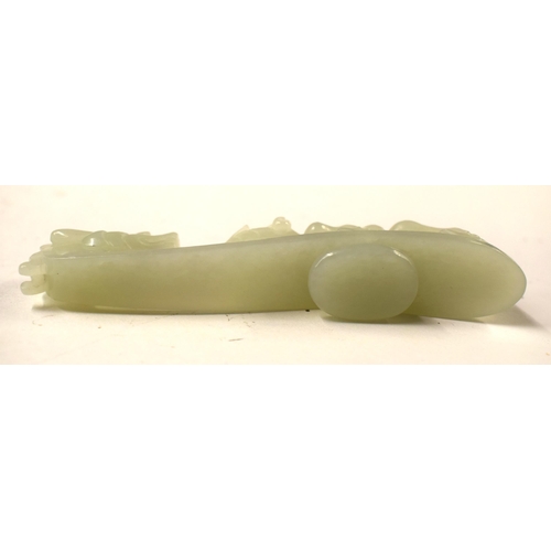 487 - A 19TH CENTURY CHINESE CARVED GREENISH JADE BELT HOOK together with a stone beast. Largest 11cm wide... 