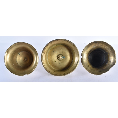 535 - A GROUP OF THREE 17TH CENTURY BRASS CAPSTAN CANDLESTICKS with tapered sockets and candle stub ejecto... 