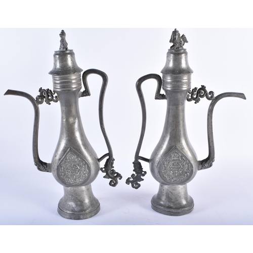 1005 - AN UNUSUAL PAIR OF 19TH CENTURY CHINESE PEWTER EWERS Qing, decorated with a buddhistic emblem. 34 cm... 