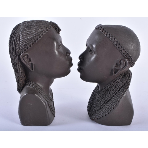 614 - A PAIR OF AFRICAN KENYAN CERAMIC BUSTS OF A MAASAI LADY AND GENTLEMAN by Apollo. 13 cm high.