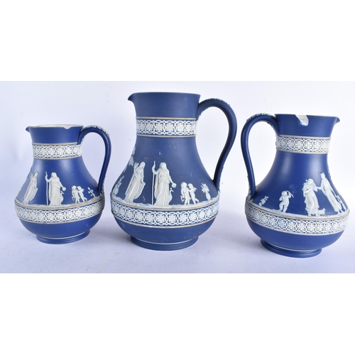 677 - A GRADUATED SET OF THREE ANTIQUE WEDGWOOD JASPERWARE JUGS. Largest 20 cm x 12 cm. (3)