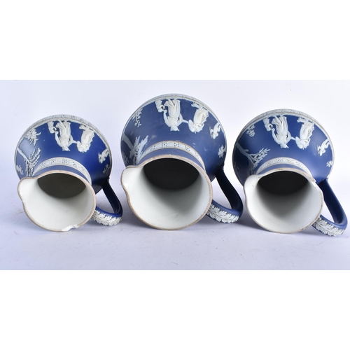 677 - A GRADUATED SET OF THREE ANTIQUE WEDGWOOD JASPERWARE JUGS. Largest 20 cm x 12 cm. (3)