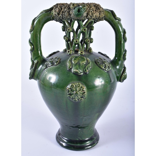 696 - AN UNUSUAL ANTIQUE GREEN GLAZED TWIN HANDLED POTTERY PUZZLE JUG. 22 cm high.