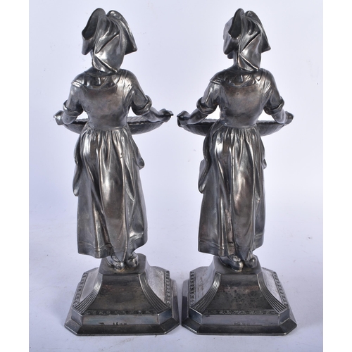 707 - A PAIR OF EARLY 20TH CENTURY WMF PEWTER SWEETMEAT FIGURAL DISHES modelled as females holding out fla... 