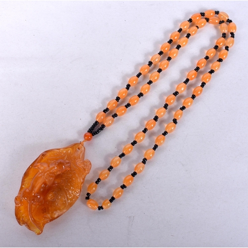 939 - AN EARLY 20TH CENTURY CHINESE CARVED AMBER NECKLACE Late Qing/Republic. 51 grams. 76 cm long, pendan... 