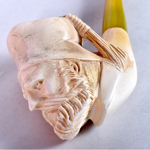 953 - A MEERSCHAUM AND AMBER TIPE MASK PIPE. 15 cm long.