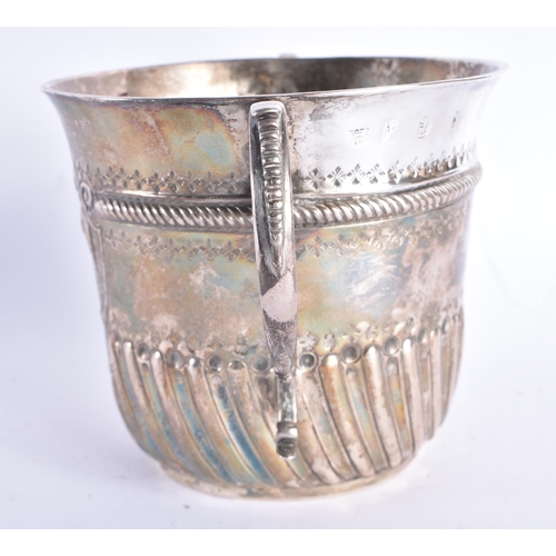 298 - AN EARLY ENGLISH TWIN HANDLED SILVER REPOUSSE PORRINGER decorated with an acanthus capped monogram. ... 