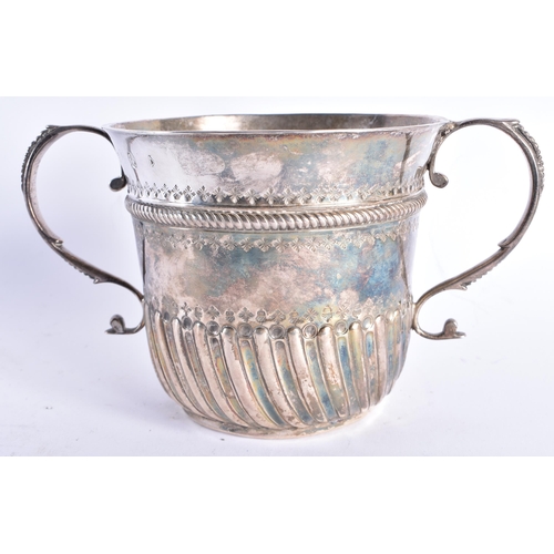 298 - AN EARLY ENGLISH TWIN HANDLED SILVER REPOUSSE PORRINGER decorated with an acanthus capped monogram. ... 