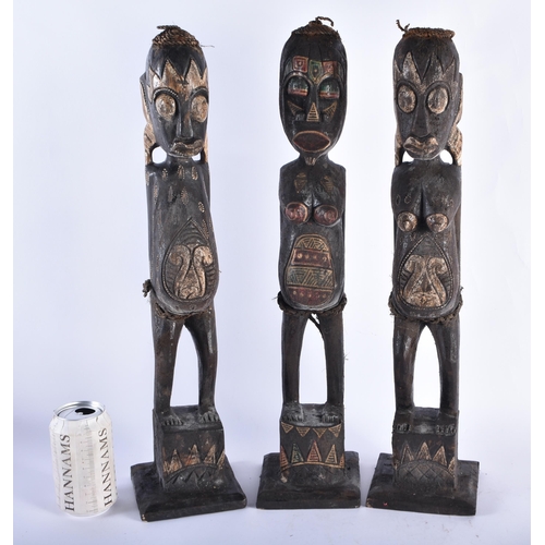 61 - A SET OF THREE CARVED WOOD TRIBAL FIGURES. 50 cm high. (3)