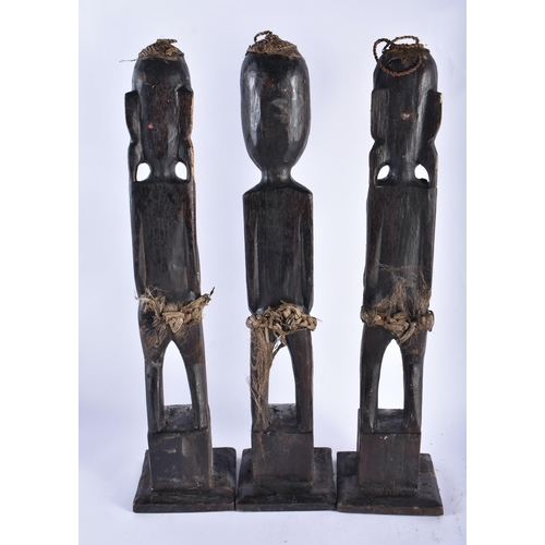 61 - A SET OF THREE CARVED WOOD TRIBAL FIGURES. 50 cm high. (3)