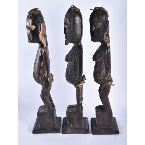 61 - A SET OF THREE CARVED WOOD TRIBAL FIGURES. 50 cm high. (3)