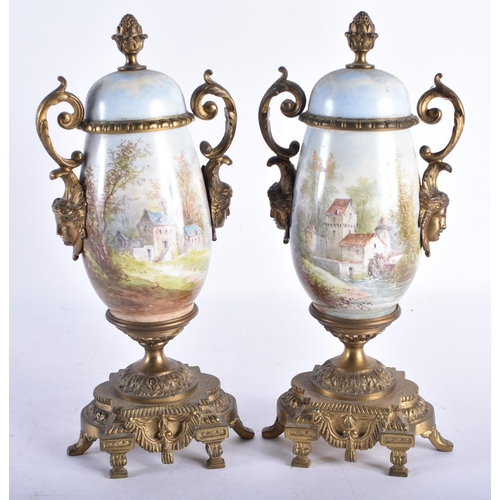 716 - A PAIR OF 19TH CENTURY FRENCH TWIN HANDLED PORCELAIN URNS painted with landscapes. 25 cm high.