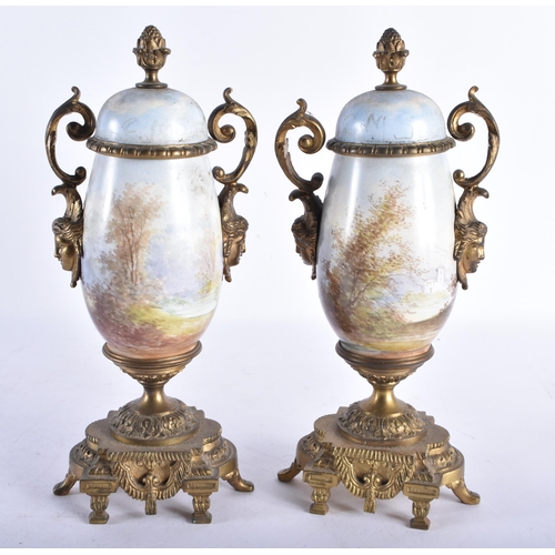 716 - A PAIR OF 19TH CENTURY FRENCH TWIN HANDLED PORCELAIN URNS painted with landscapes. 25 cm high.