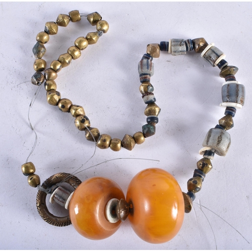 751 - AN UNUSUAL TRIBAL AMBER TYPE GLASS AND GILT BEAD NECKLACE. 130 grams. 50 cm long.